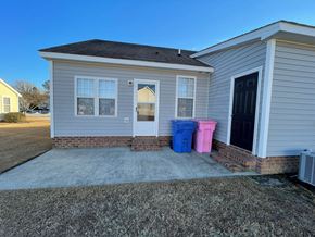 Wilson apartment for rent - A house with a grey exterior has a blue and pink container outside.