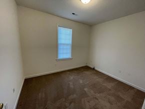 Wilson apartment for rent - A room with a carpeted floor and a window with blinds.