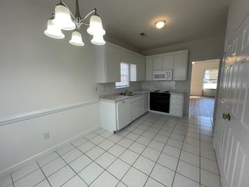 Wilson apartment for rent - A kitchen with white cabinets and a white fridge.