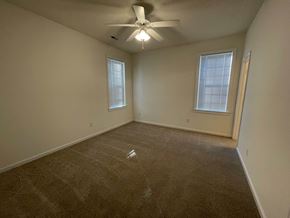 Rocky Mount apartment for rent - A room with a ceiling fan and two windows.