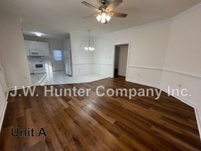 Wilson apartment for rent - A spacious room with wooden flooring and a ceiling fan.