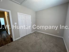 Wilson apartment for rent - A room with a carpeted floor and a white door.
