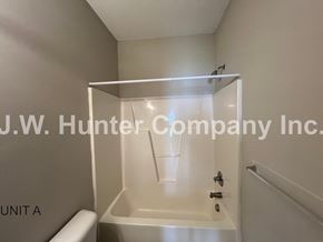 Wilson apartment for rent - A white bathroom with a tub and toilet.