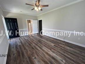Wilson apartment for rent - A room with wooden flooring and a ceiling fan.