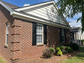 Wilson apartment for rent - A red brick house with a white roof and black shutters.