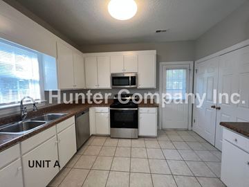 Wilson apartment for rent - A kitchen with white cabinets and a brown countertop.