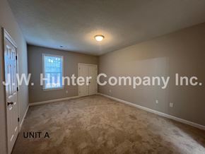 Wilson apartment for rent - A room with carpet flooring and a window with blinds.