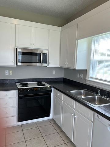 Wilson apartment for rent - A kitchen with white cabinets and black countertops.