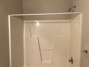 Wilson apartment for rent - A white shower stall with a white door and a white shelf above it.