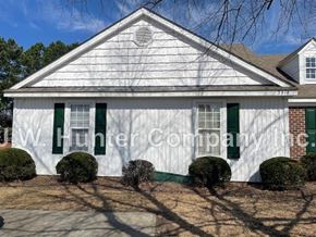 Wilson apartment for rent - A white house with green shutters and a brick chimney.