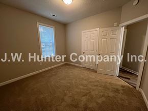 Wilson apartment for rent - A room with carpet flooring and a window with a view of a building outside.