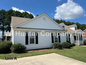Wilson apartment for rent - A white house with black shutters and a watermark that reads "Hunter Company".