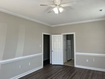 Wilson apartment for rent - an empty living room with a ceiling fan and a door to a closet