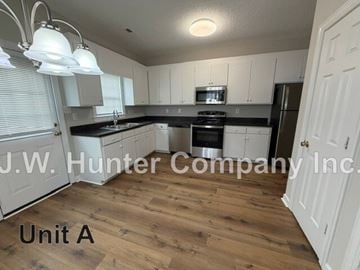 Wilson apartment for rent - A kitchen with white cabinets and a black stove top oven.
