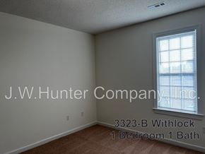Wilson apartment for rent - A room with a window and carpeting, with the text J.W. Hunter Company, Inc. and 3323-B Withlock 1 Bedroom 1 Bath.