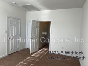 Wilson apartment for rent - A room with a carpet floor and a door open to another room.