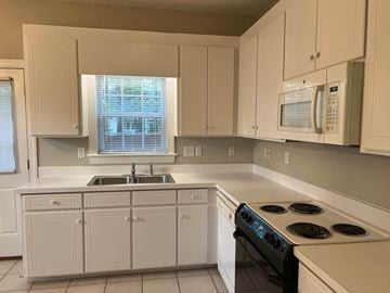 Wilson apartment for rent - A kitchen with white cabinets and a black stove top.