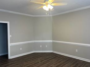 Wilson apartment for rent - A room with a ceiling fan and light fixture, and a wooden floor.