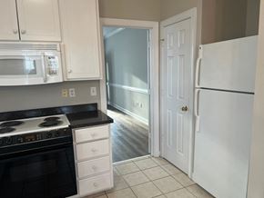 Wilson apartment for rent - A kitchen with a stove, microwave, and refrigerator.
