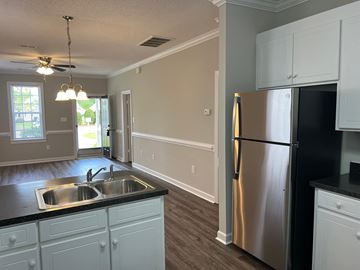 Wilson apartment for rent - A kitchen with a stainless steel refrigerator and white cabinets.