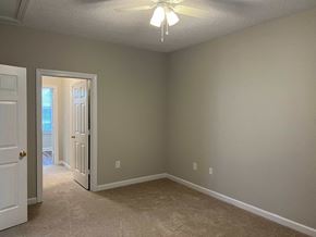 Wilson apartment for rent - A room with a carpeted floor and a ceiling fan.