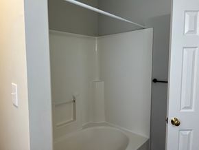 Wilson apartment for rent - A white bathroom with a tub and a door.