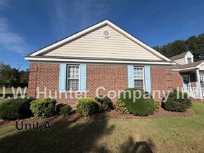 Wilson apartment for rent - A brick house with blue shutters and a sign that says J.W. Hunter Company Inc.