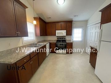 Wilson apartment for rent - A kitchen with brown cabinets and a white refrigerator.
