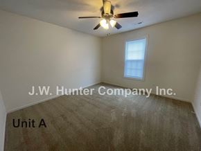 Wilson apartment for rent - A room with a carpet floor and a ceiling fan.