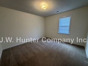 Wilson apartment for rent - A room with a carpeted floor and a window with blinds.