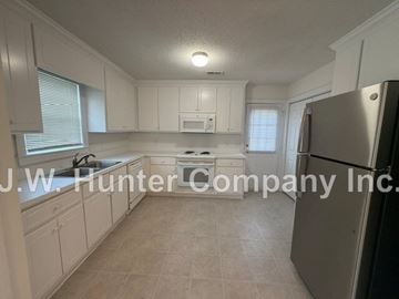 Wilson apartment for rent - A kitchen with white cabinets and a tiled floor.