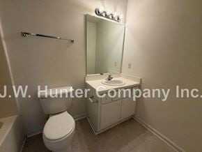 Wilson apartment for rent - A white toilet sits next to a sink in a small bathroom.