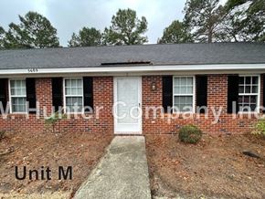Wilson apartment for rent - A brick house with a white door and windows with shutters.