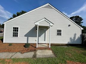 Wilson apartment for rent - A small white building with a door and windows.