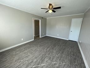 Wilson apartment for rent - A room with a ceiling fan and grey flooring.