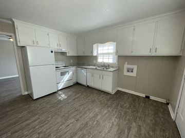 Wilson apartment for rent - A kitchen with white appliances and cabinets.