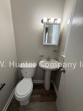 Wilson apartment for rent - A white toilet in a small bathroom with a mirror above it.