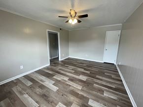 Wilson apartment for rent - A room with a ceiling fan and wooden flooring.