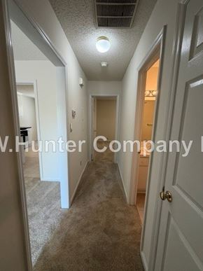 Wilson apartment for rent - A hallway with carpeted floors and white walls.