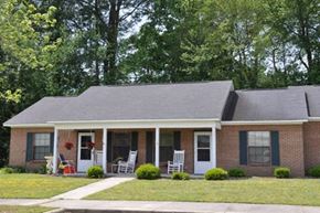 Wilson apartment for rent - a brick house with two rocking chairs in front of it