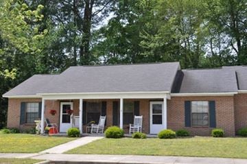 Wilson apartment for rent - a brick house with two rocking chairs in front of it