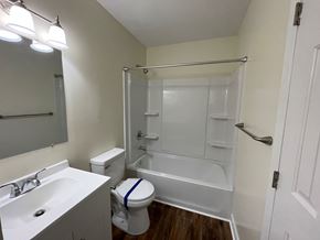 Wilson apartment for rent - A white bathroom with a toilet, sink, and shower.