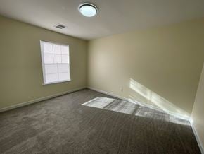 Wilson apartment for rent - A room with a carpeted floor, a window with blinds, and a ceiling light.