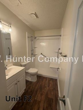 Wilson apartment for rent - A bathroom with a toilet, sink, and shower.