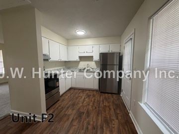 Wilson apartment for rent - A kitchen area with wooden floors and white cabinets.