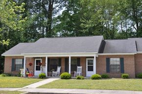 Wilson apartment for rent - a brick house with two rocking chairs in front of it