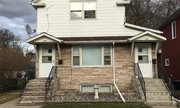 Fargo apartment for rent - A two-story house with a white front and a brown brick wall.