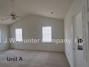 Wilson apartment for rent - A spacious room with a ceiling fan and carpeted floor.