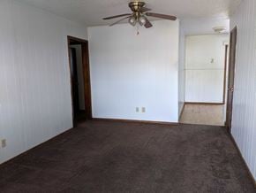 Stillwater house for rent - A room with a ceiling fan and carpeted floor.