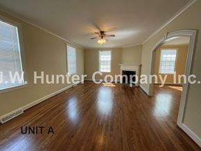 Wilson apartment for rent - A spacious room with wooden floors and a ceiling fan.